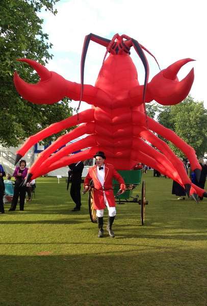 Large red lobster sculpture in a park