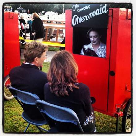 Couple in a red photo booth with a sign