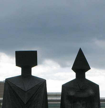 Two black sculptures silhouetted against the sky