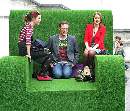 Three people sitting on a green sofa outdoors